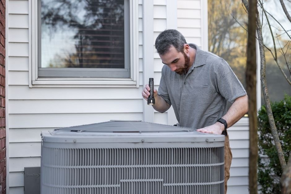 Ice Team technician servicing a residential air conditioning condenser unit outside a Miami-area home